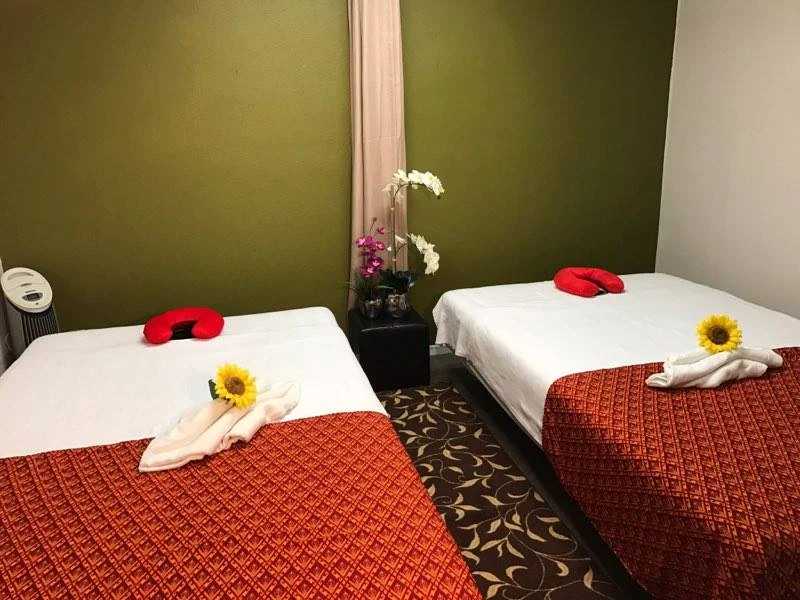 A peaceful couples treatment room at Luxury Thai Massage, with flowers on each massage bed